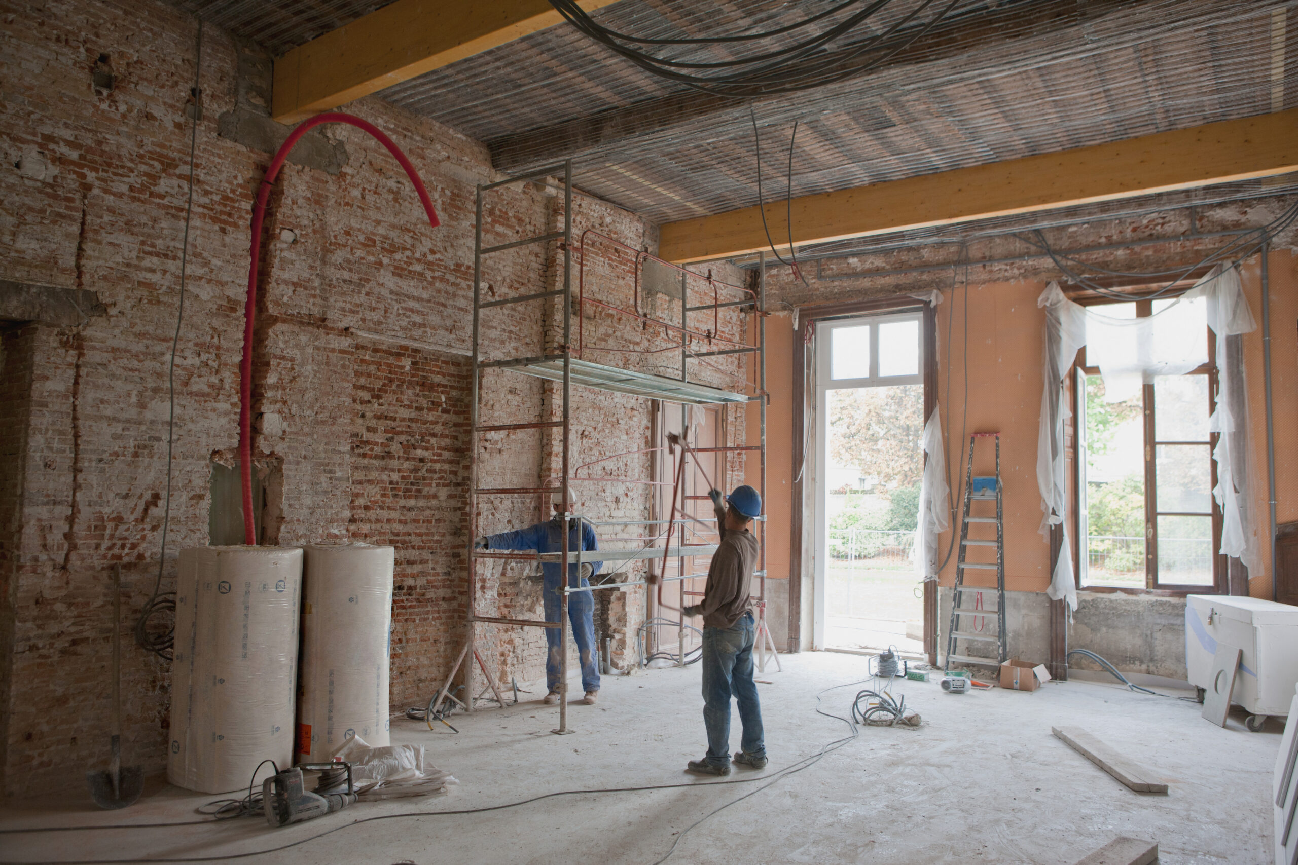 Constructie van een nieuwbouwproject met bouwmaterialen en werkers op locatie