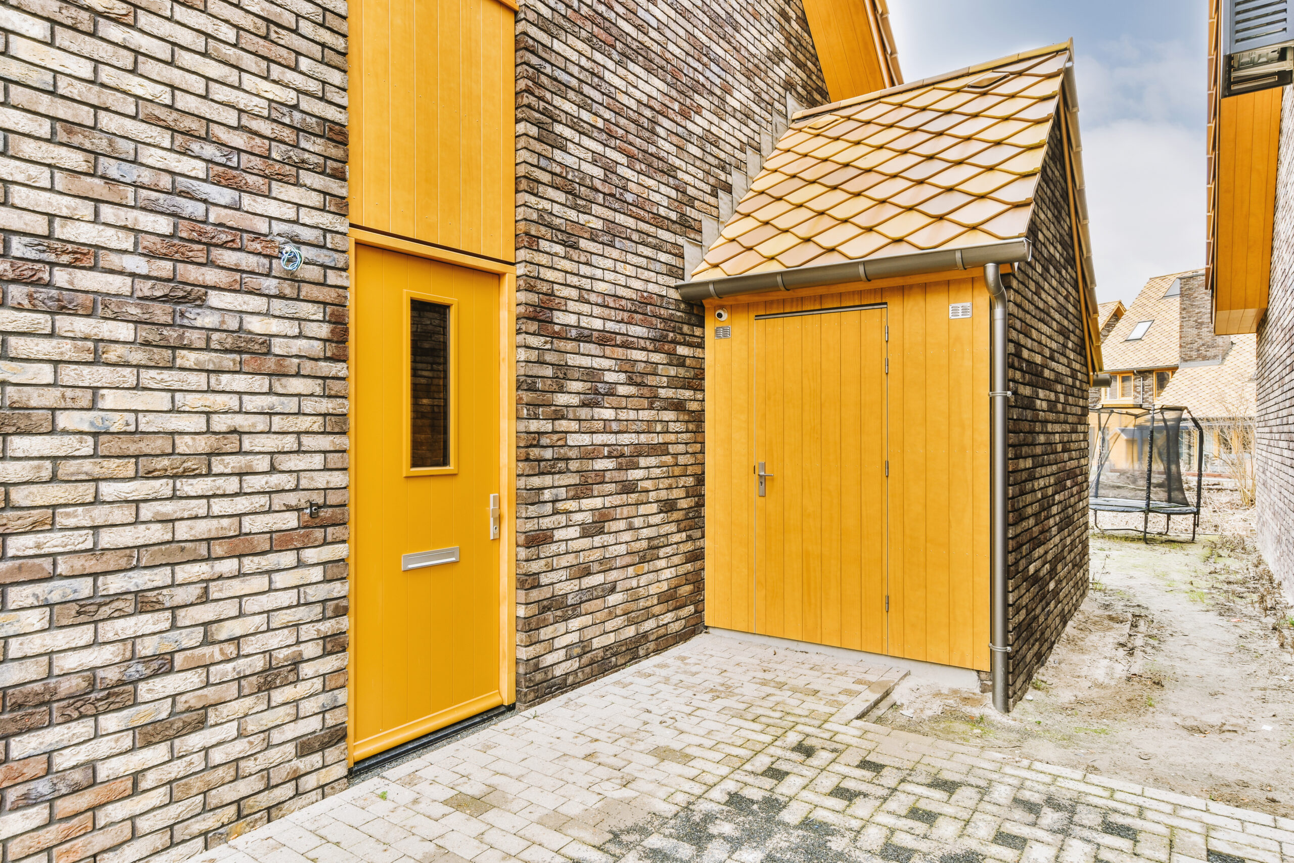 Een gerenoveerde entree van een modern huis met bakstenen gevel.