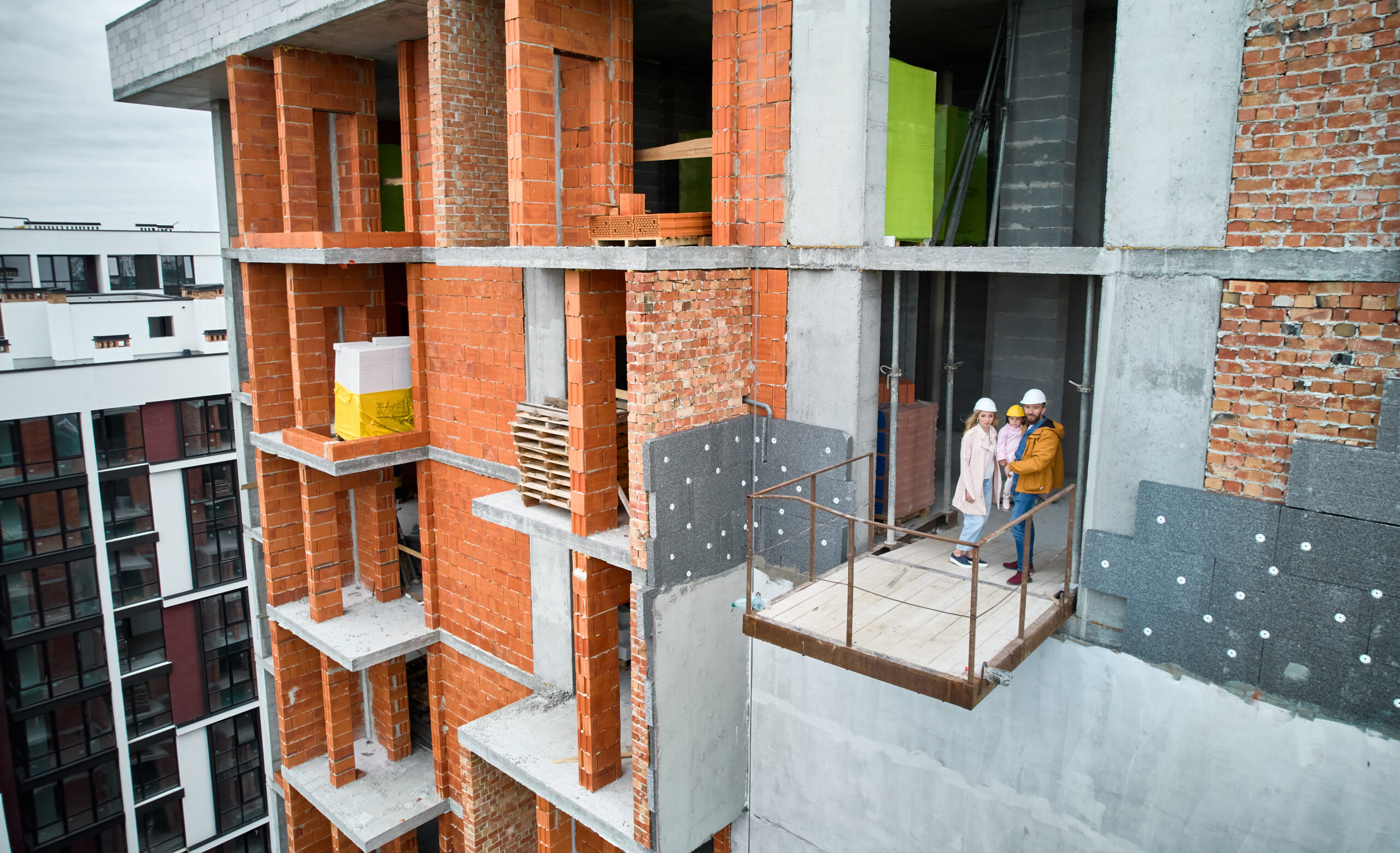 Een bouwteam van Bouwbedrijf Darsi B.V. staat samen in een nieuwbouwproject, symbool voor het creëren van ruimtes waar mensen kunnen wonen, werken en groeien.
