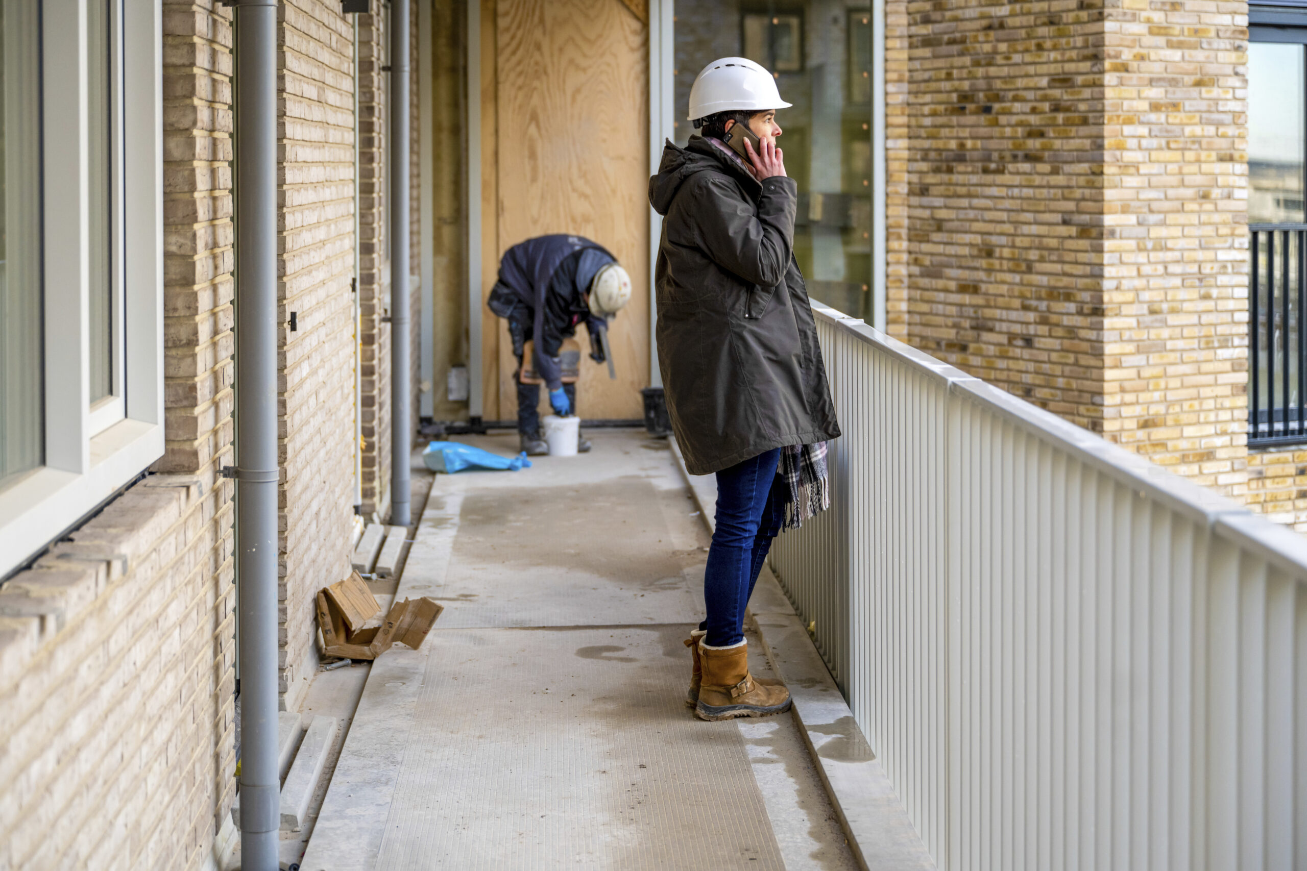 Bouwmanager inspecteert onderhoudswerkzaamheden aan een appartementencomplex.