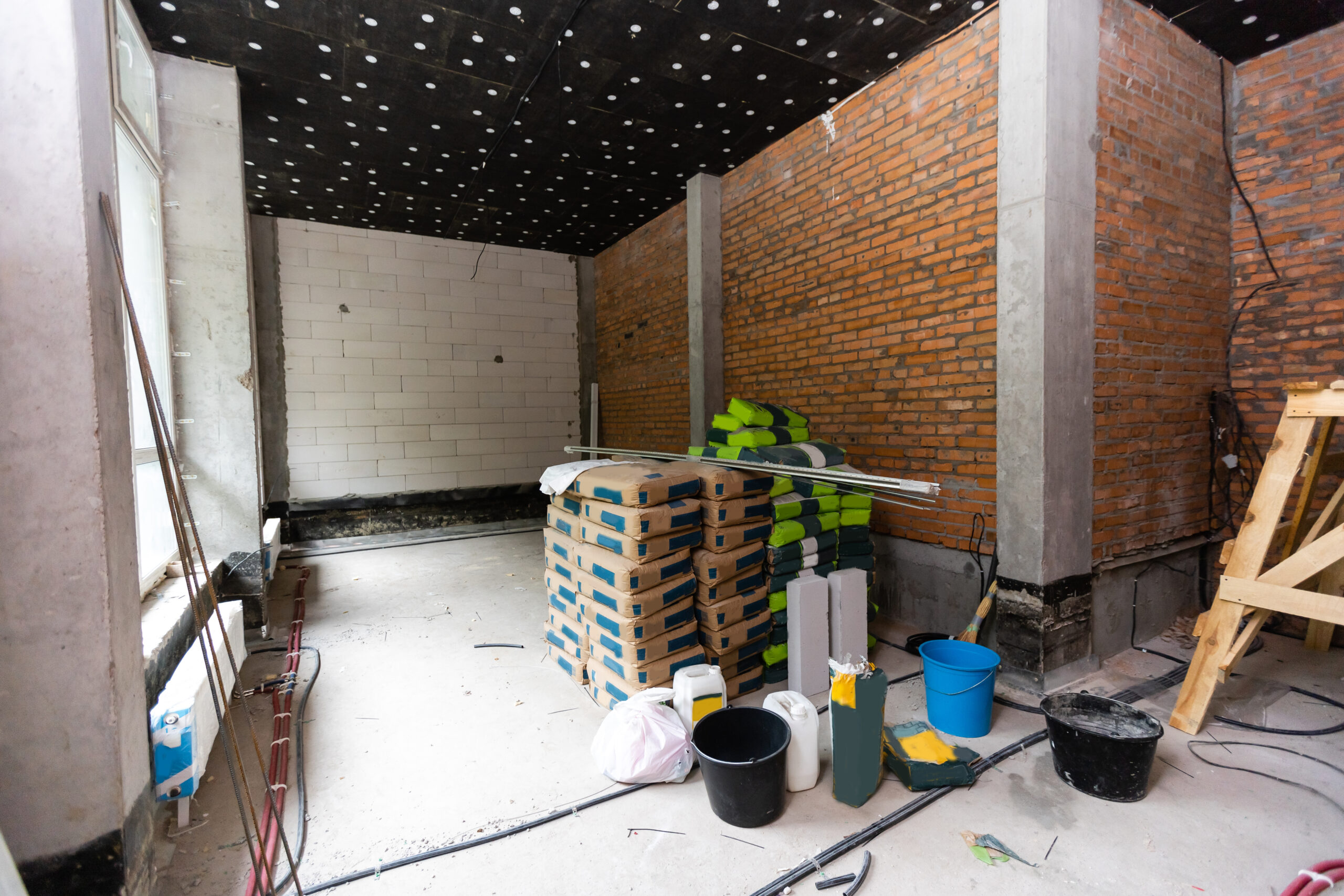 Interieur van een duurzaam woonproject in aanbouw met stapels bouwmaterialen en isolatiepanelen.