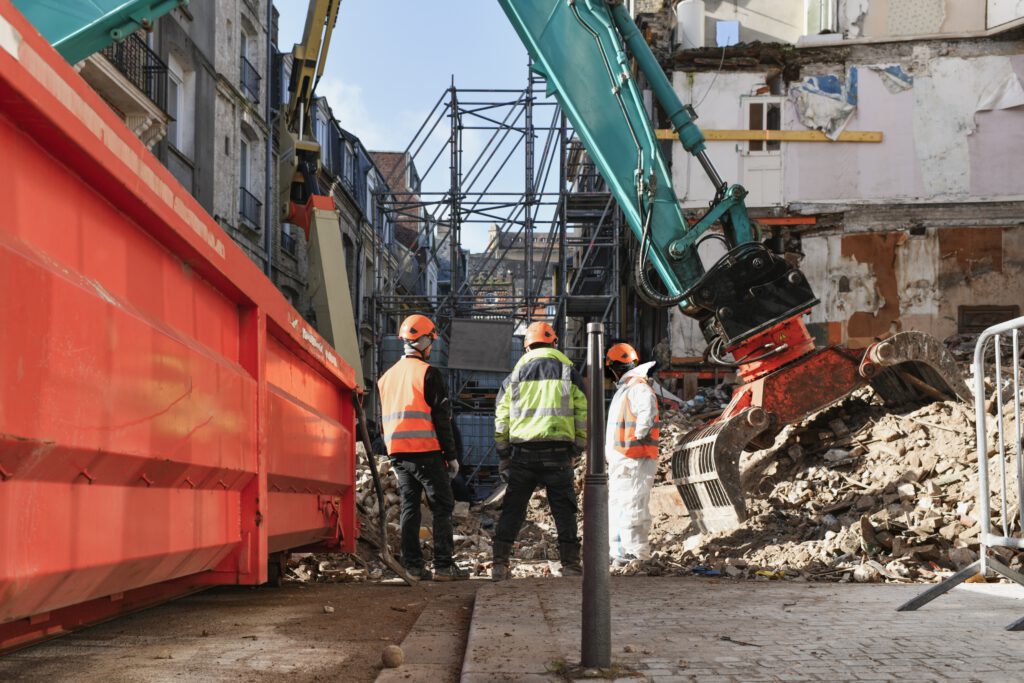 Professioneel team van Bouwbedrijf DARSI B.V. bezig met sloopwerkzaamheden in Noord-Holland, omgeven door bouwpuin en graafmachines in een stedelijke omgeving